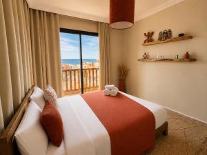 a bedroom with a bed with a teddy bear sitting on it at Arya Imsouane in Imsouane