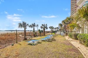 a row of lounge chairs on the beach at Carolinian Beach Resort in Myrtle Beach +11 photos