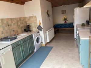 a kitchen with a sink and a washing machine at Le Chalet des Vignes in Saint-Laurent-des-Vignes