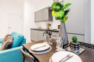 a living room with a table and a blue couch at Sleeps 2 - Central - Studio - WiFi - Paid Parking in Maidstone +3 photos