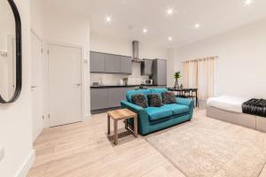 a living room with a blue couch and a bedroom at Sleeps 2 - Central - Studio - WiFi - Paid Parking in Maidstone