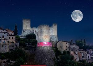 a castle at night with the moon in the sky at Domus Aura in Itri +50 photos