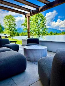 a patio with chairs and a table and a view of the water at SeeChalet Hallstatt in Bad Goisern