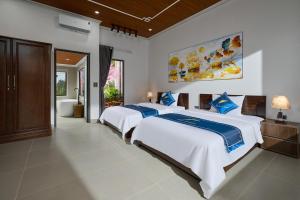 a bedroom with two beds and a bathroom at Hoa Lư - An Resort in Ninh Binh +16 photos