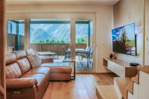 a living room with a couch and a large window at Cozy Corner in Bovec