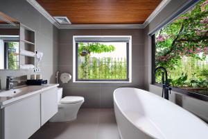 a bathroom with a tub and a sink and a window at Hoa Lư - An Resort in Ninh Binh