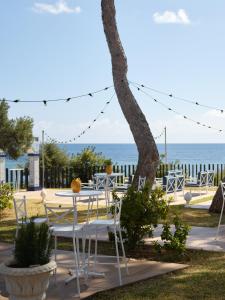 a table and chairs with the ocean in the background at Hotel Mongibello Ibiza in Santa Eularia des Riu