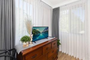 a tv on a dresser in a room with a window at BJ Mick's Lakefront Apartment in Forster +29 photos
