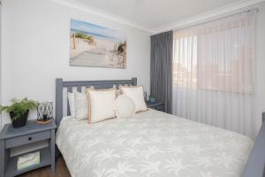 a bedroom with a bed and a window at BJ Mick's Lakefront Apartment in Forster