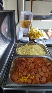 a table with trays of food on a counter at Hotel Super Economico in Vitória