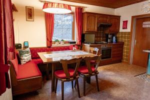 a kitchen with a table and a red couch at Die Hornbacherin in Rottenmann