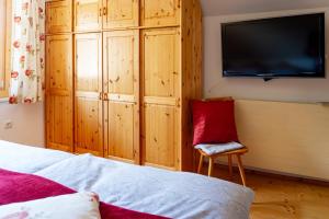 a bedroom with a bed and a tv and a chair at Die Hornbacherin in Rottenmann