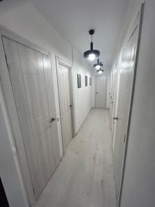 an empty hallway with white walls and white doors at Хостел Мануфактура in Kharkiv