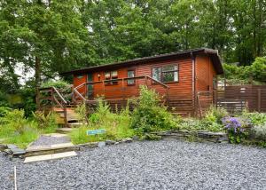 a cabin in the woods with a gravel yard at Garth Holiday Park in Machynlleth