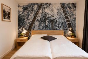 a bedroom with a white bed and a wall mural at Erica in Folgaria +66 photos