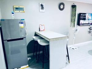 a kitchen with a refrigerator and a counter with stools at Khaleejay Transient House in Calapan +4 photos