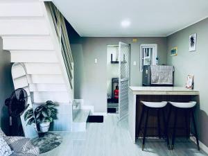 a living room with a staircase and a counter at Khaleejay Transient House in Calapan