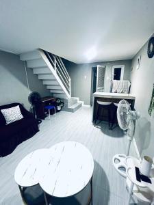 a living room with a white table and stairs at Khaleejay Transient House in Calapan