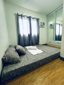 a large bed in a room with a window at Khaleejay Transient House in Calapan
