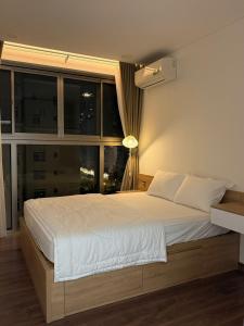 a bedroom with a large white bed with a window at Premium Midtown serviced apartment in Ho Chi Minh City +19 photos
