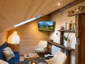 a living room with a tv on a wooden wall at Apt Mystère, Résidence Bel Air in Montriond