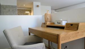 a desk and a chair in a room with a table at Suite Cotinga, balneo, bien-être, Parc des Oiseaux in Villars-les-Dombes +4 photos