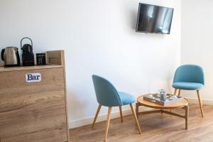 two chairs and a table in a room with a tv at Suite Cotinga, balneo, bien-être, Parc des Oiseaux in Villars-les-Dombes