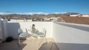 a table and chairs on a balcony with a view at Elegante Apartamento de 1 Dormitorio en Nerja in Nerja
