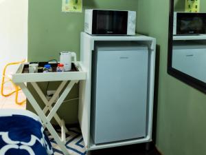 a white refrigerator with a microwave on top of it at Zakumi Guesthouse in Kokstad