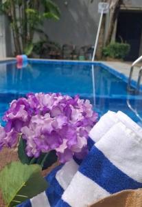 a bouquet of purple flowers sitting next to a pool at Paradise Inn in Kandy
