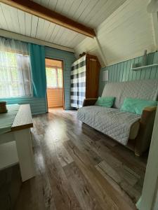 a bedroom with a bed and a wooden floor at Tleniowo Domek in Tleń +18 photos