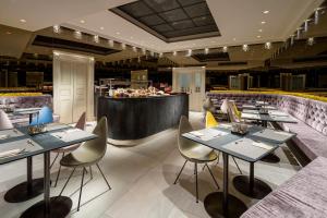 a restaurant with tables and a bar in the background at Mamaison Hotel Riverside Prague in Prague