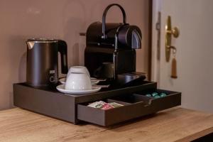 a black tray with a coffee maker on a counter at Wohnkultur - DSIGNIO Ladenburg Digital Hotel in Ladenburg