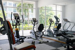 un gimnasio con varias cintas de correr y máquinas elípticas en Resort by Harsh, en Pattaya central
