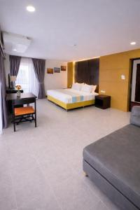 una habitación de hotel con cama y escritorio en Resort by Harsh, en Pattaya central