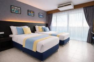 una habitación de hotel con dos camas y una ventana en Resort by Harsh, en Pattaya central