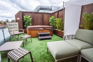 a patio with a couch and chairs and a hot tub at Barack Thermal Hotel and Spa in Tiszakécske