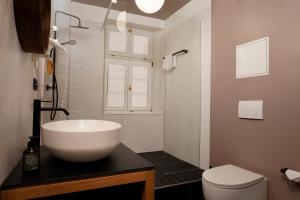a bathroom with a white sink and a toilet at Wohnkultur - DSIGNIO Ladenburg Digital Hotel in Ladenburg