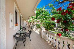 a balcony with tables and chairs and red flowers at Apartments Al Parma in Budva +42 photos