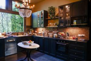 a large kitchen with blue cabinets and a table at Boutique hotel Villa Trompenberg in Hilversum