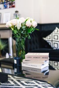a stack of books on a table with a vase of flowers at Mitre Hotel Manchester City Centre in Manchester +141 photos