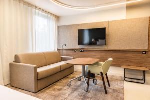 a living room with a couch and a table at Novotel Suites Rouen Normandie in Rouen