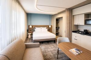a hotel room with a bed and a table at Novotel Suites Rouen Normandie in Rouen