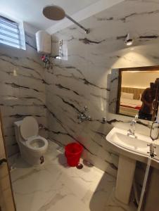 a bathroom with a toilet and a sink and a mirror at Sunview Resort in Mandarmoni +35 photos