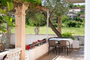a table and chairs on a patio with a tree at Apartments Al Parma in Budva