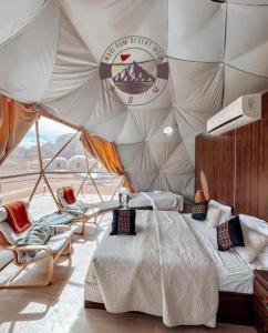 a bedroom with a bed and chairs in a tent at WADI RUM DESERt MOON in Wadi Rum +150 photos