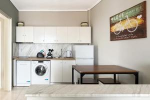a kitchen with a washing machine and a table at Rona Vista Suites cozy veranda in Polychrono