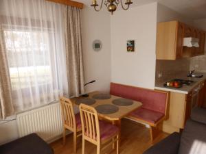 Haus Südblick Appartements في سيفيلد ان تيرول: مطبخ صغير مع طاولة وكراسي في الغرفة