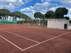 a tennis court in front of a building at Hotel Franca in Milano Marittima