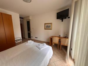 a bedroom with a bed and a table and a television at Albergo Lario in Gera Lario
